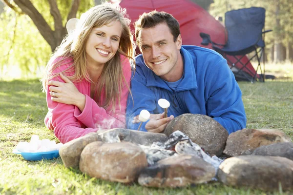 火のキャンプでマシュマロを焼くことのカップル — ストック写真