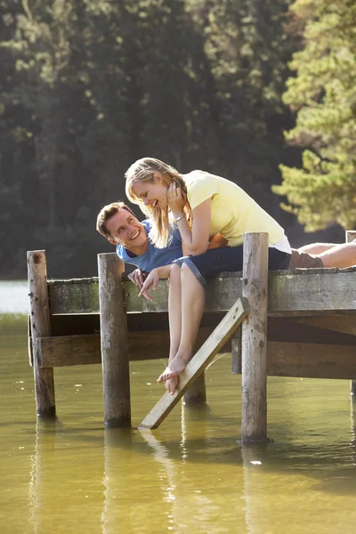 Romantische paar zittend op de houten steiger — Stockfoto