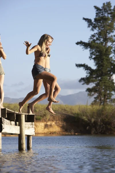 Femmes sautant de la jetée dans le lac — Photo