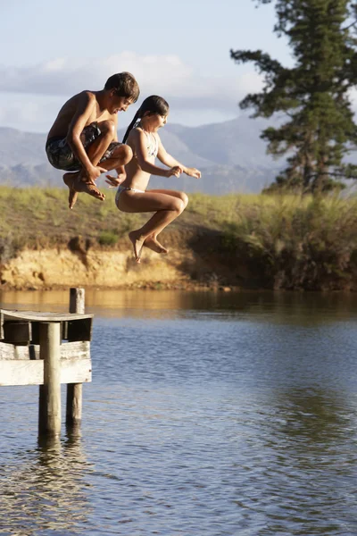 Crianças saltando do molhe no lago — Fotografia de Stock