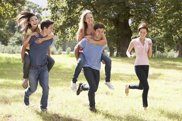 Groupe d'amis courant à travers la campagne — Photo