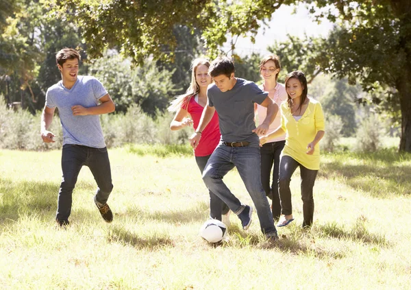 Grupo de amigos jugando al fútbol en el campo — Foto de Stock