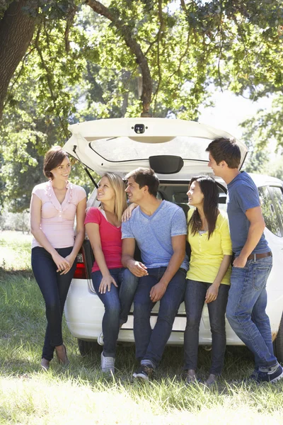 Grupp av vänner som sitter i bagageluckan på bilen — Stockfoto