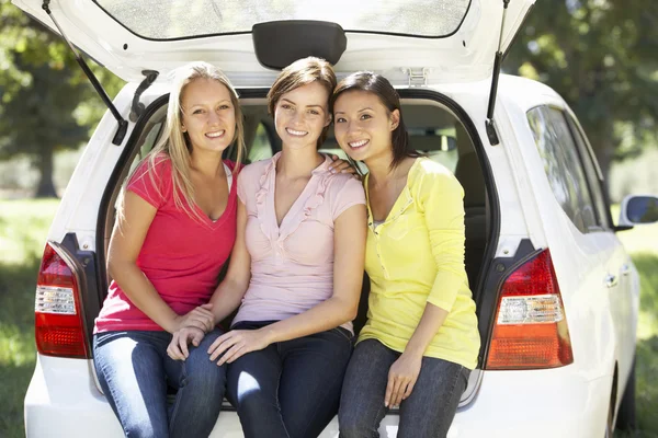 Tre kvinnor sitter i bagageluckan på bilen — Stockfoto