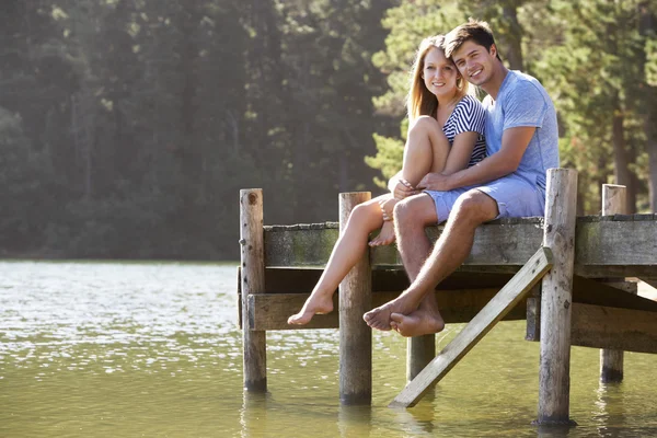 Romantiska par sitter på träbryggan — Stockfoto
