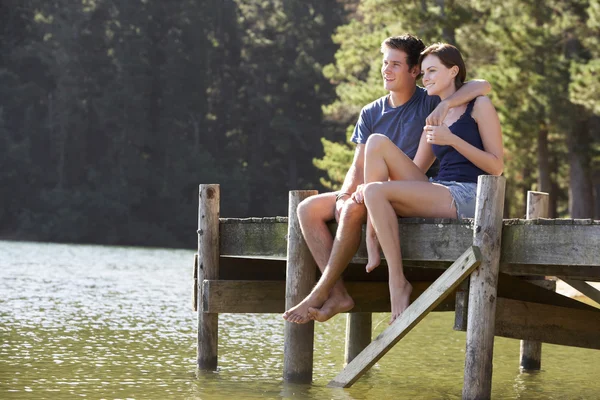 Coppia romantica seduta sul molo di legno — Foto Stock