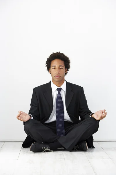 Uomo d'affari seduto sul pavimento e meditare — Foto Stock