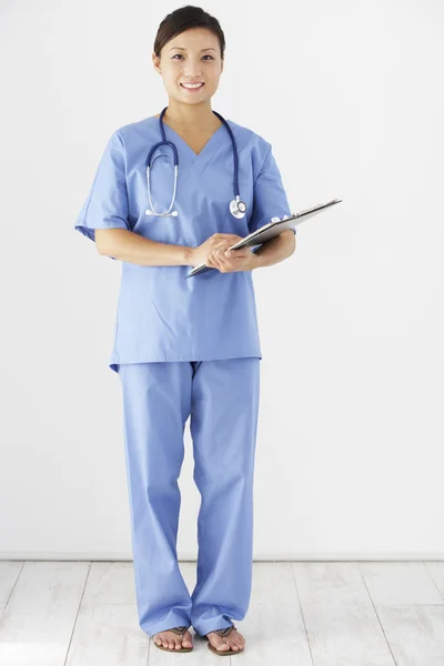 Krankenschwester mit Klemmbrett blickt in Kamera — Stockfoto