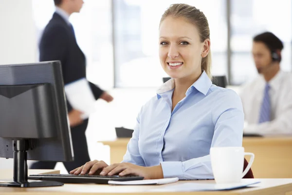 Businesswoman Working At Desk In Busy Office — Stock Photo, Image