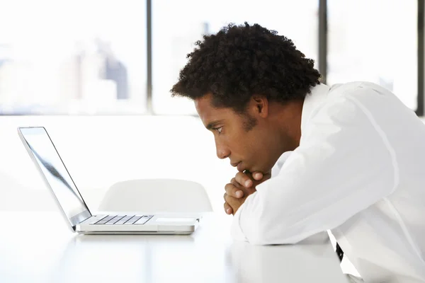 Empresario mirando fijamente a la computadora portátil — Foto de Stock