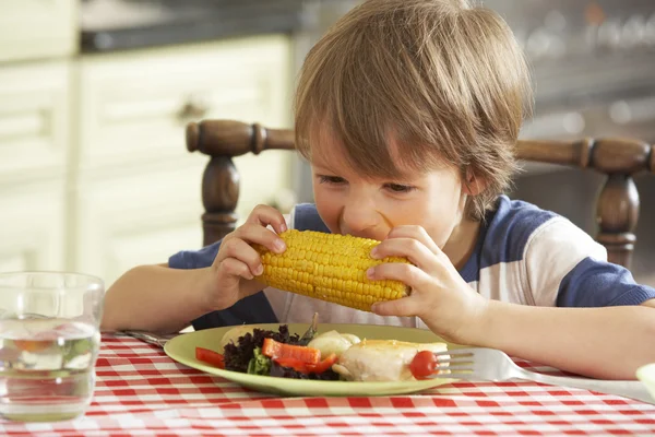 Giovane ragazzo mangiare pasto in cucina — Foto Stock