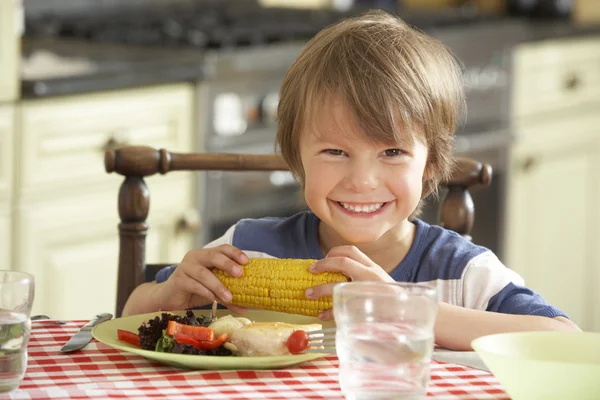 Junge isst Mahlzeit in Küche — Stockfoto