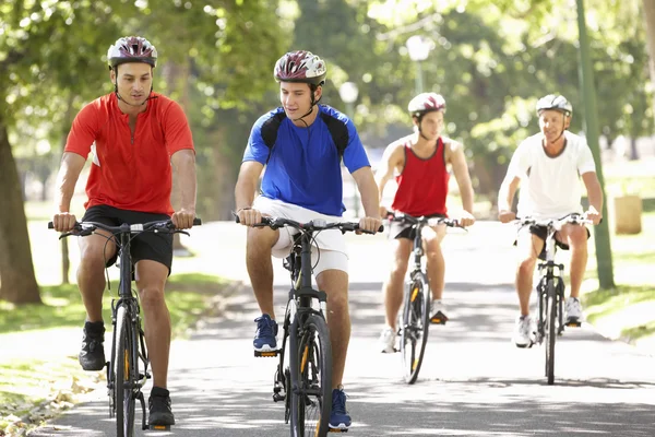 Homens em passeio de bicicleta através do parque Fotografias De Stock Royalty-Free