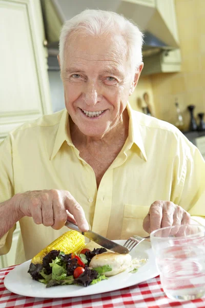 Senior Man Eating Meal In Kitchen — Stock Photo, Image