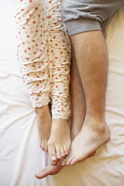 Détail des jambes du couple se détendre au lit — Photo