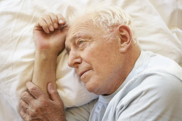 Senior mannen avkopplande i sängen — Stockfoto