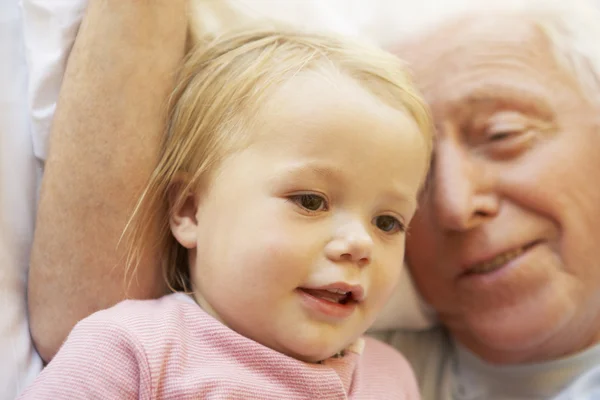 Дедушка обнимает внучку в постели — стоковое фото