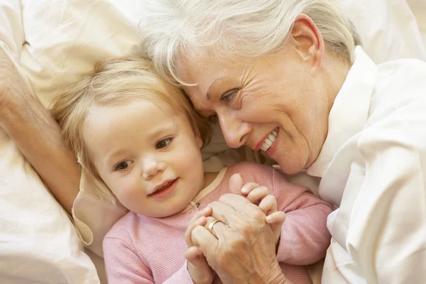 Großmutter kuschelt Enkelin im Bett — Stockfoto