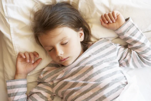 Mladá dívka spí v posteli — Stock fotografie