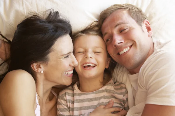 Familjen koppla av i sängen — Stockfoto