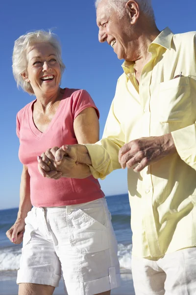 Senior paar loopt langs het strand — Stockfoto