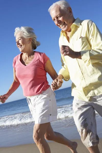 Couple aîné courant le long de la plage — Photo