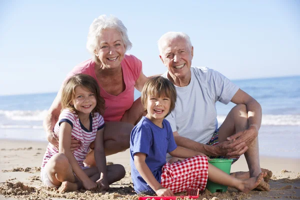 Großeltern und Enkel am Strand — Stockfoto
