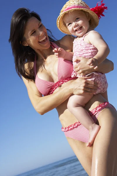 Moeder met dochter loopt langs het strand — Stockfoto