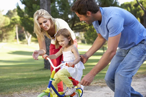 Les parents enseignent la fille à faire du vélo — Photo