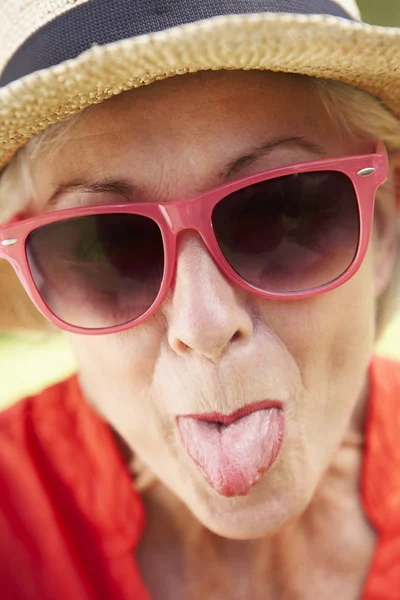 Senior vrouw die tong prikken — Stockfoto