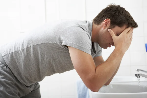 Hombre cansado en pie en el lavabo del baño — Foto de Stock