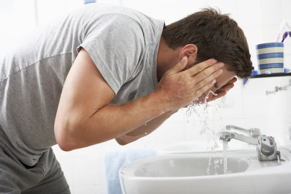 Homem lavando rosto no banheiro dissipador — Fotografia de Stock
