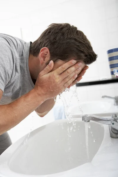 Uomo lavaggio faccia in bagno lavandino — Foto Stock