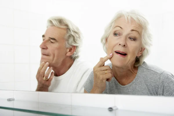 Seniorenpaar blickt auf Spiegelungen im Spiegel — Stockfoto