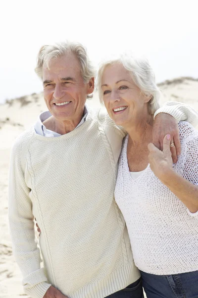 Senior paar wandelen langs strand — Stockfoto