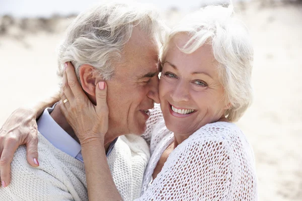 Senior paar wandelen langs strand — Stockfoto