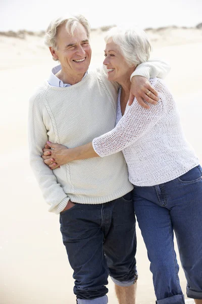 Senior paar wandelen langs strand — Stockfoto