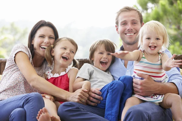 Família sentados no assento do jardim juntos — Fotografia de Stock