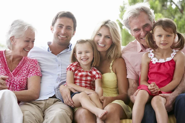 Familie sitzt auf Gartensitz — Stockfoto