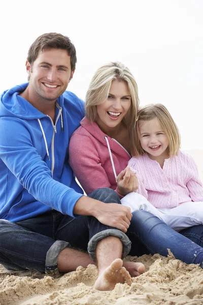 Familie zittend op strand samen — Stockfoto