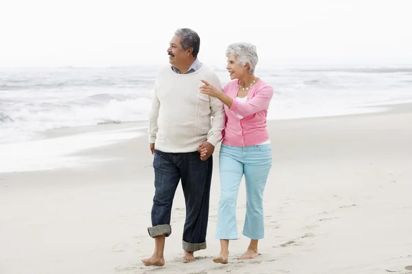 Couple aîné marchant le long de la plage — Photo