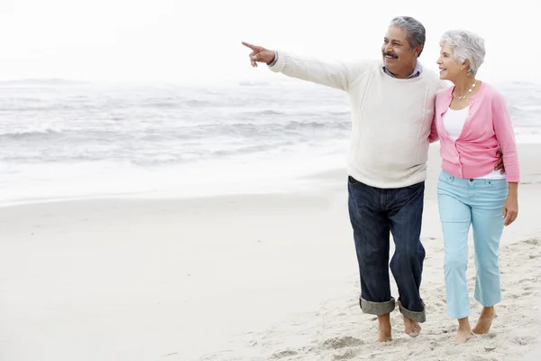 Casal sênior andando ao longo da praia — Fotografia de Stock