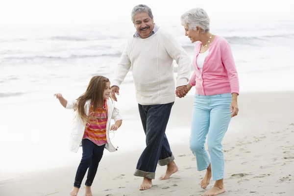 Mor-och farföräldrar med barnbarn promenader längs stranden — Stockfoto