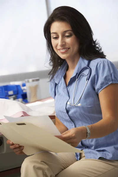 Vrouwelijke arts lezing patiënt merkt — Stockfoto
