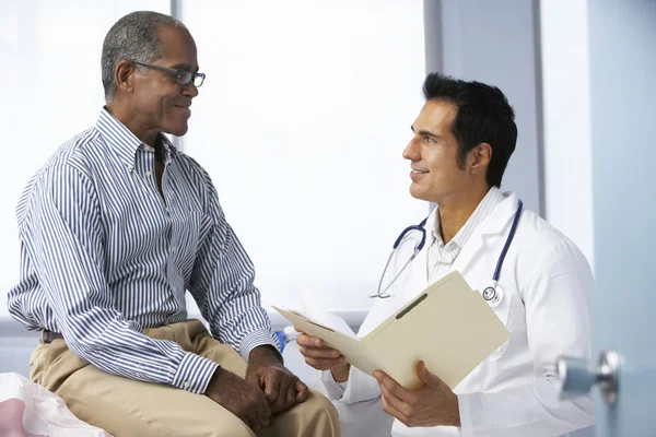 Доктор с мужскими записками о чтении пациентов — стоковое фото