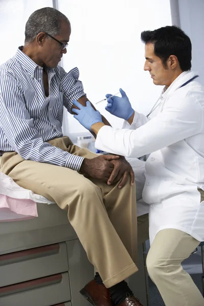 Médico que dá a injeção masculina do paciente — Fotografia de Stock