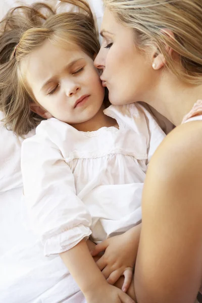 Moeder en dochter slapen in bed Stockfoto