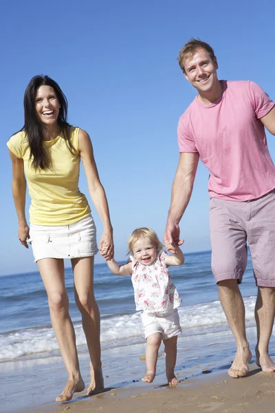 Family With Daughter Walking Along Beach Stock Image