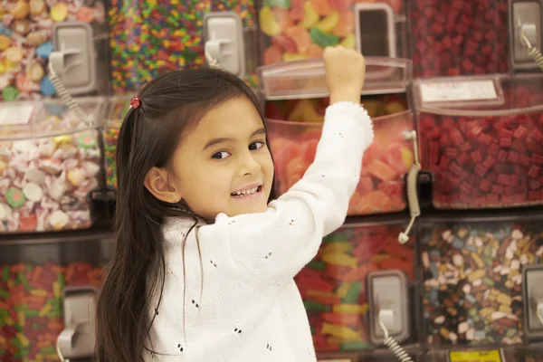 Meisje op de teller snoep In de supermarkt — Stockfoto