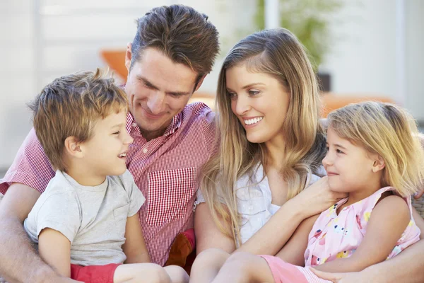 Familia sentada en el asiento del jardín juntos — Foto de Stock